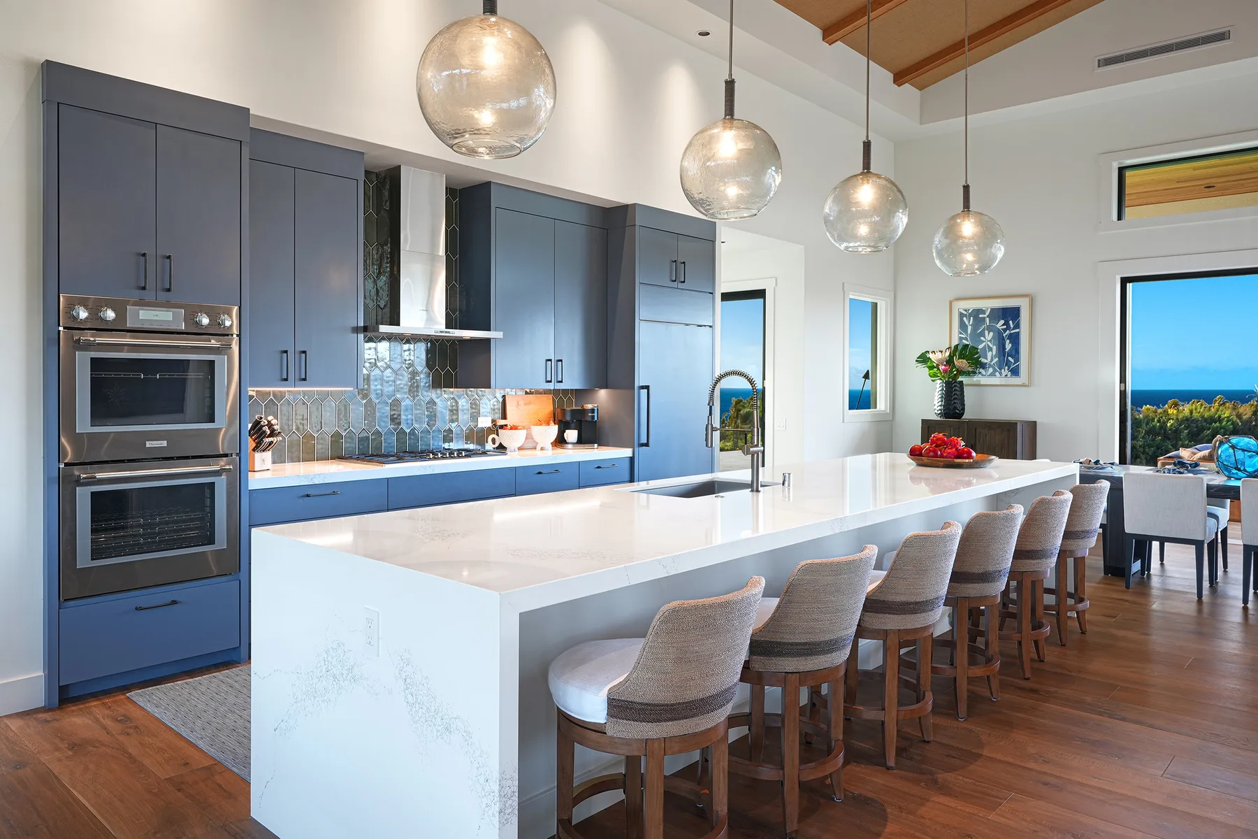 A modern kitchen with a long island and a row of counter stools.