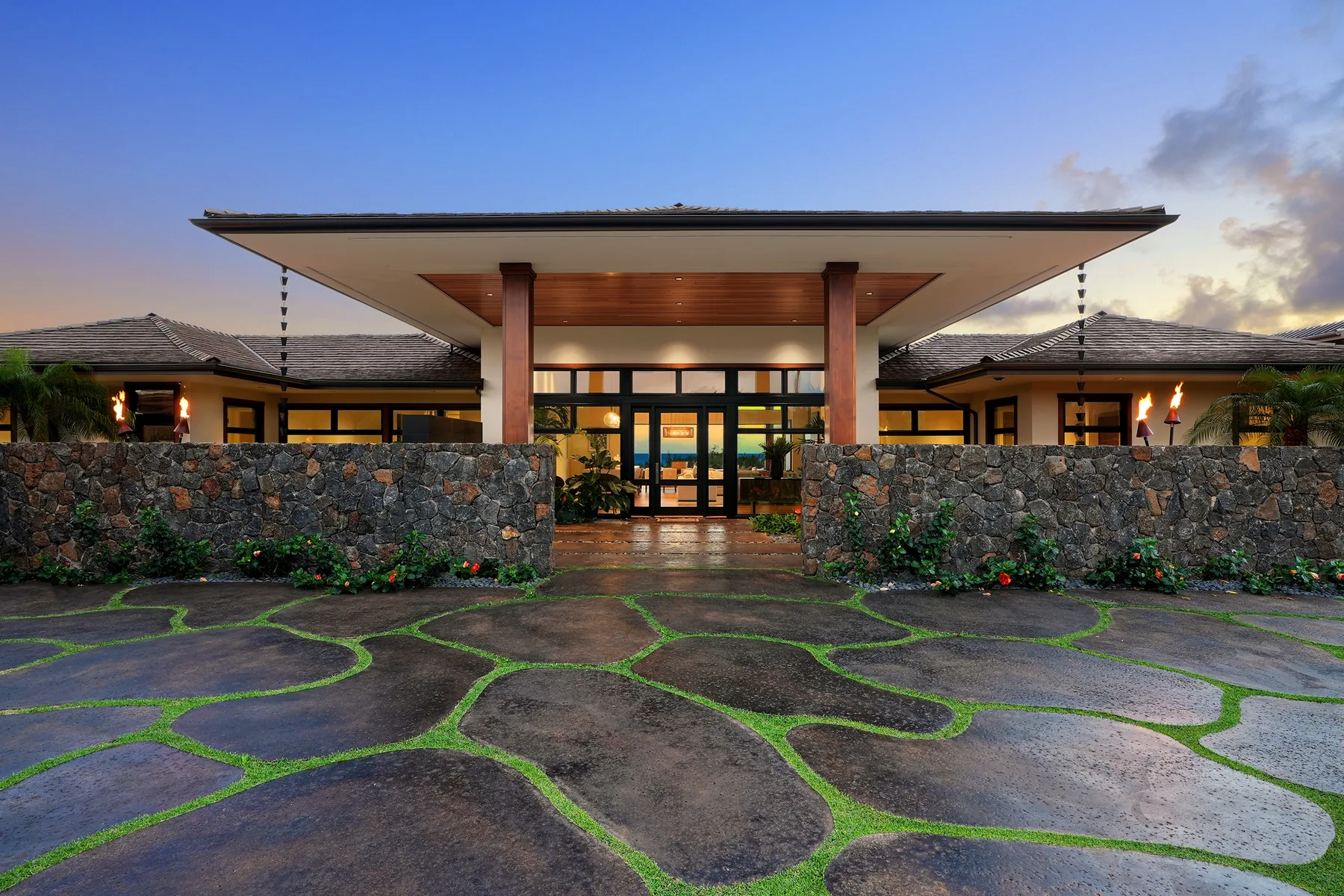 A resort-style building entrance with a broad roof and stone walls.
