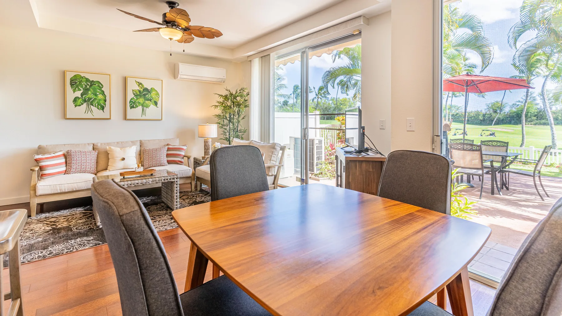 A bright dining and sitting area opens onto a patio through large glass doors.