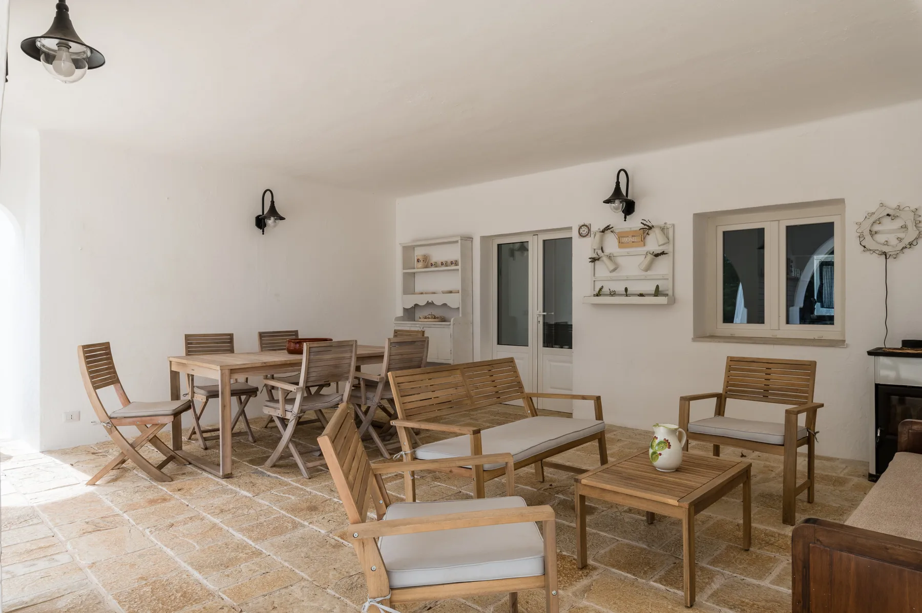 Una luminosa zona de estar en el patio con mesas y sillas de madera.