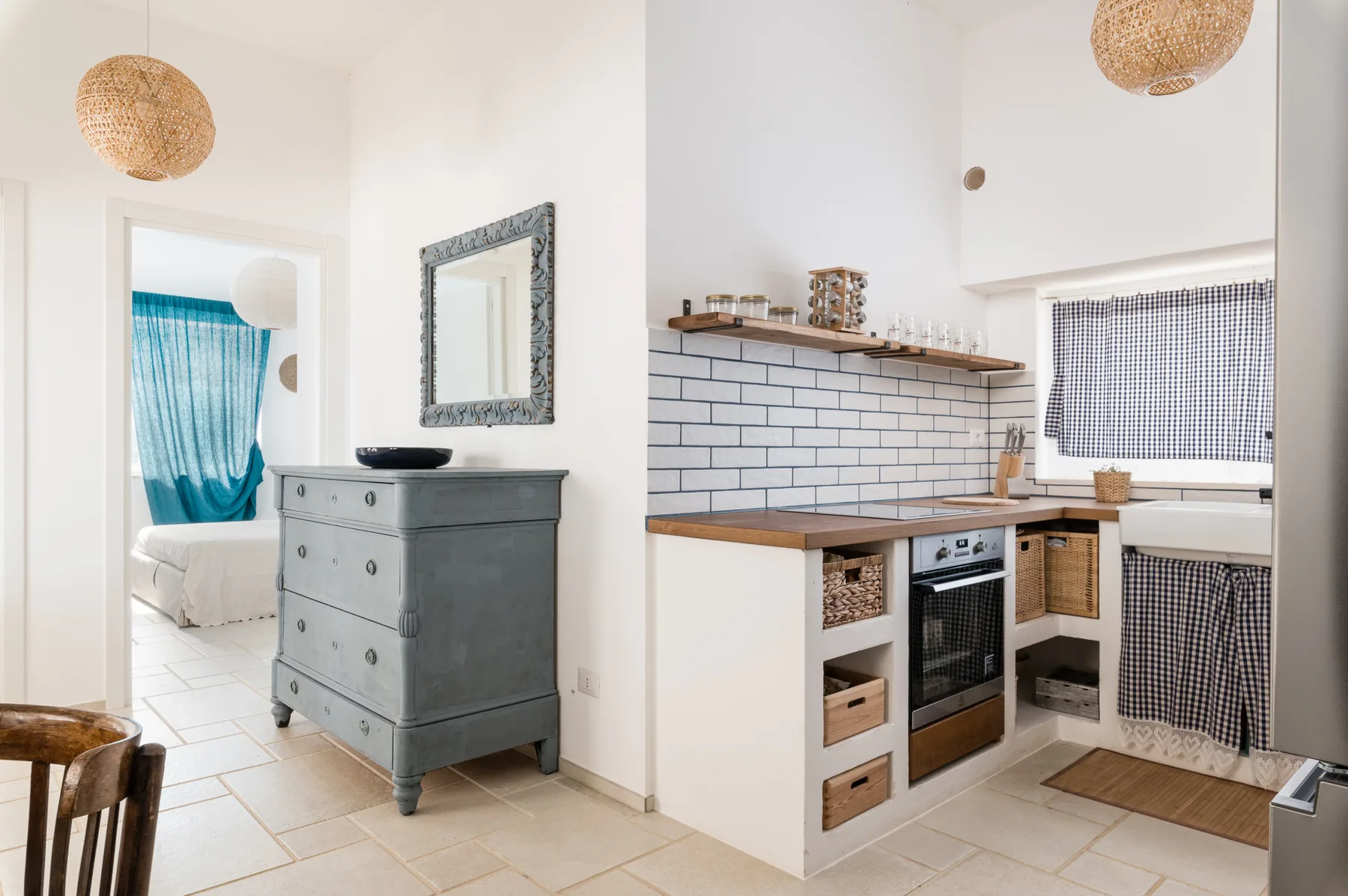 Una cocina luminosa con paredes de azulejos y una pequeña zona para comer.