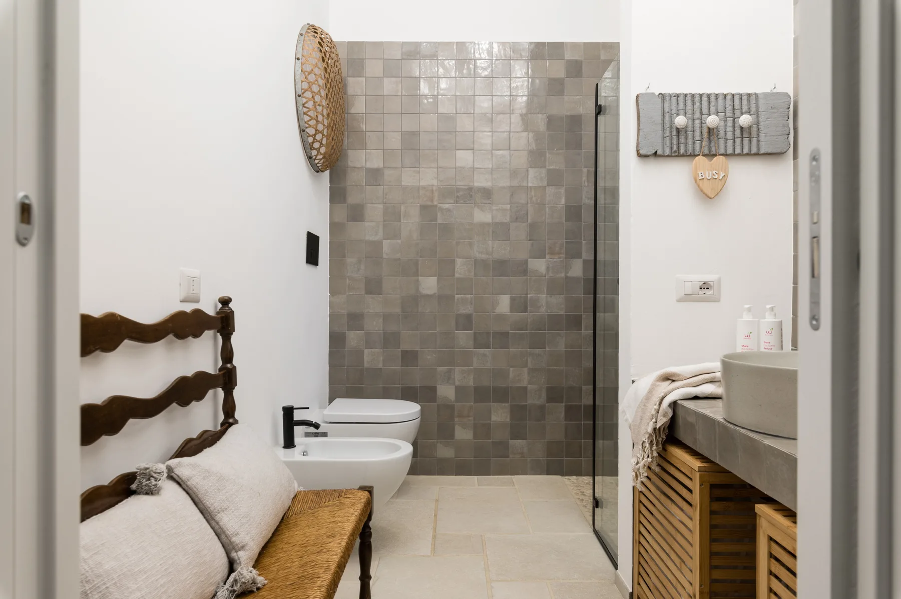 Un baño con una zona de ducha revestida de azulejos, inodoro y lavabo.