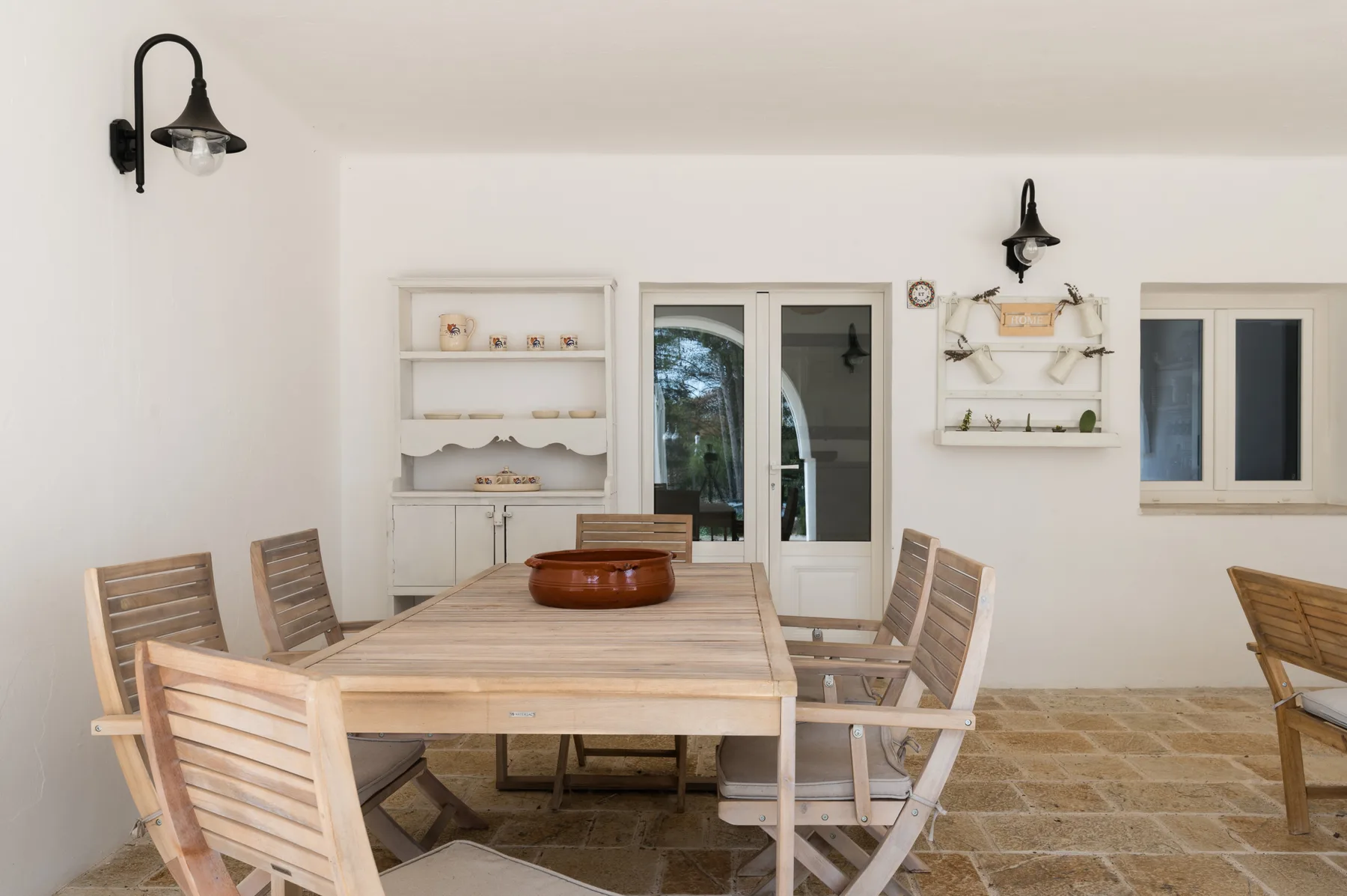 Un comedor con una mesa larga de madera y asientos a juego.