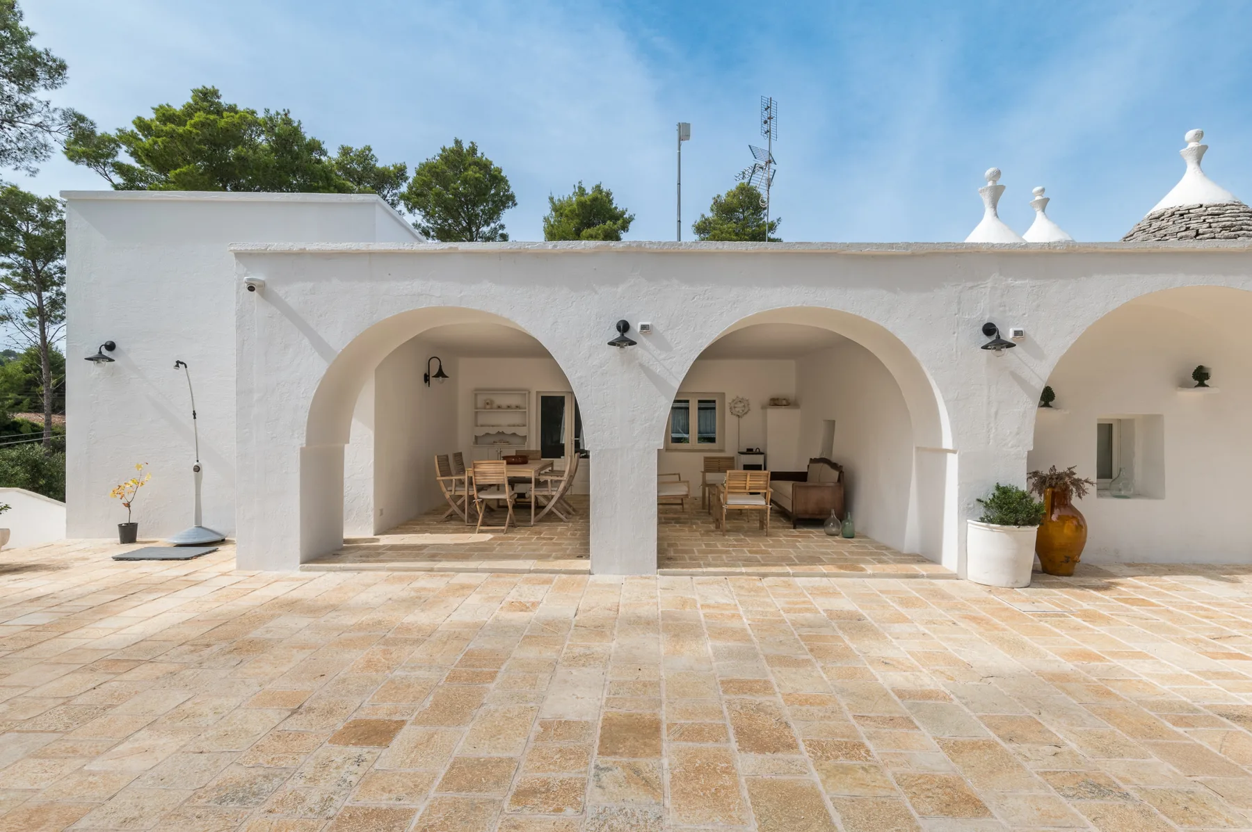 Un edificio blanco con arcos da a un amplio patio embaldosado.