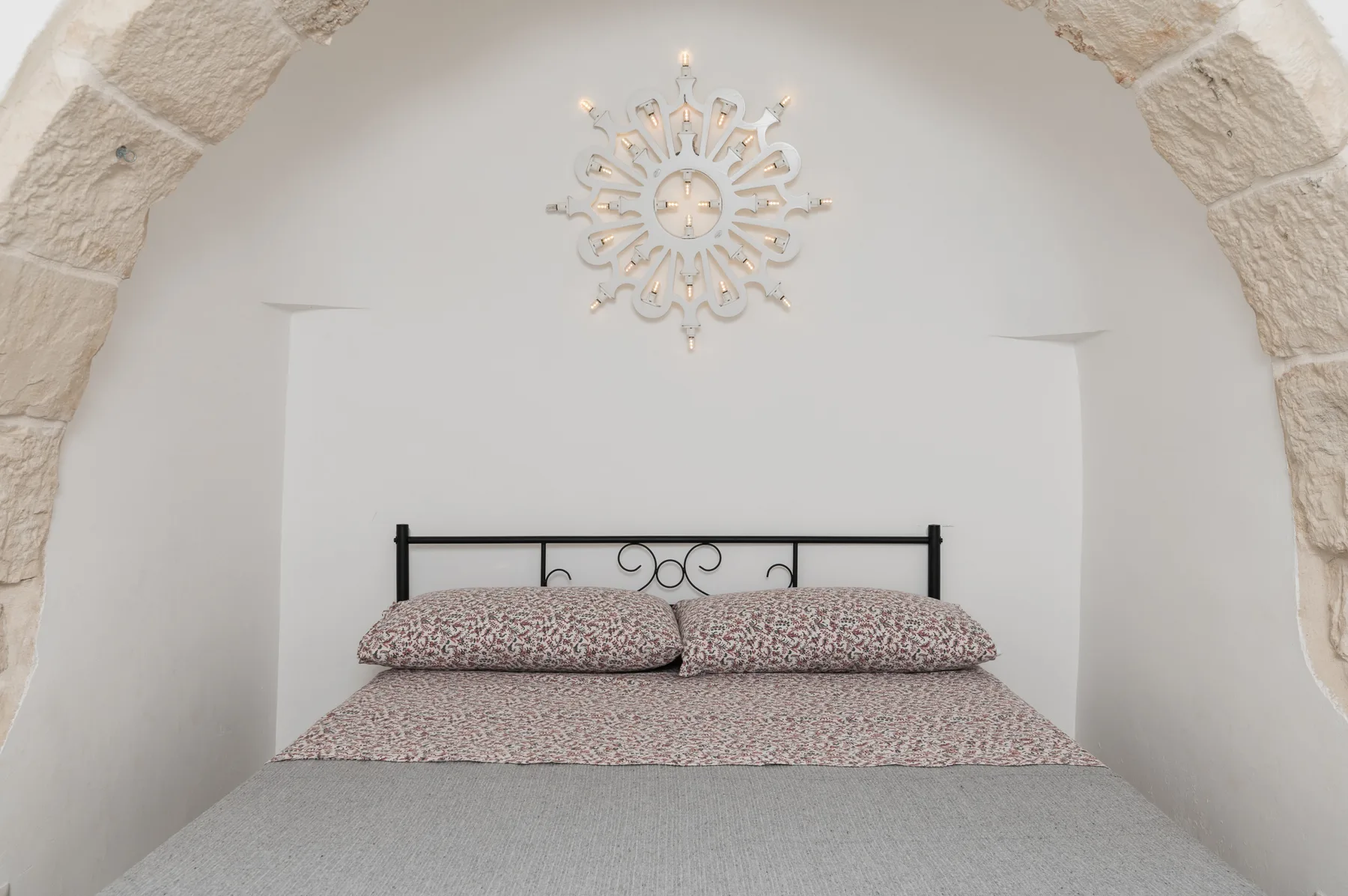 Un dormitorio con una cama bajo un reloj decorativo de pared.