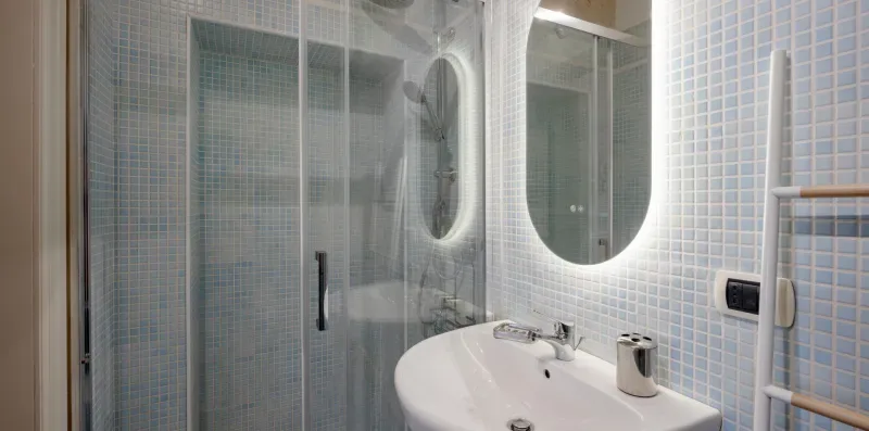 Un baño alicatado con ducha y lavabo.