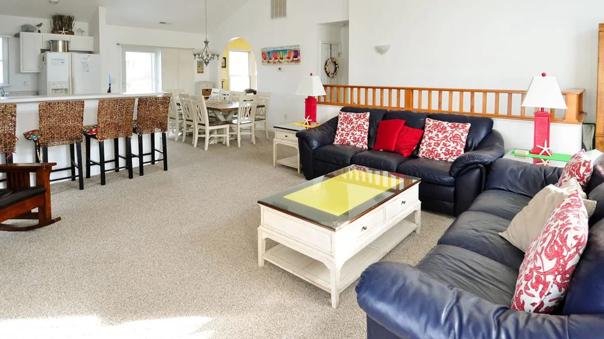 An open-plan living and dining area with dark seating and a dining table.