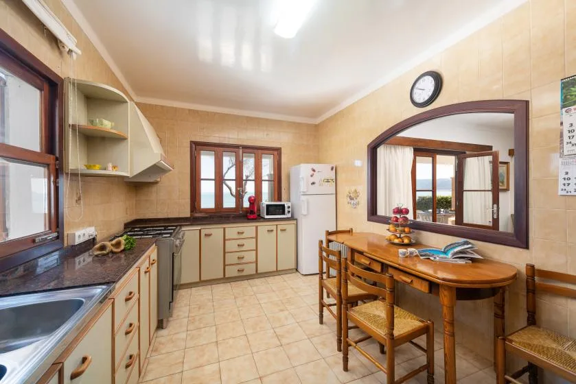 A kitchen and dining area with wooden cabinets, a table, and chairs.
