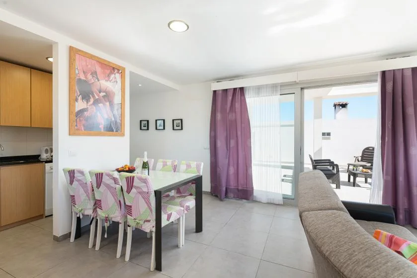 A dining area with a table and seating beside sliding glass doors.