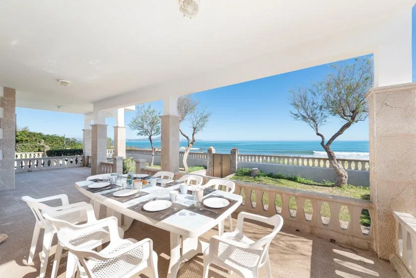 A covered terrace dining area overlooks the sea, with tables and seating.