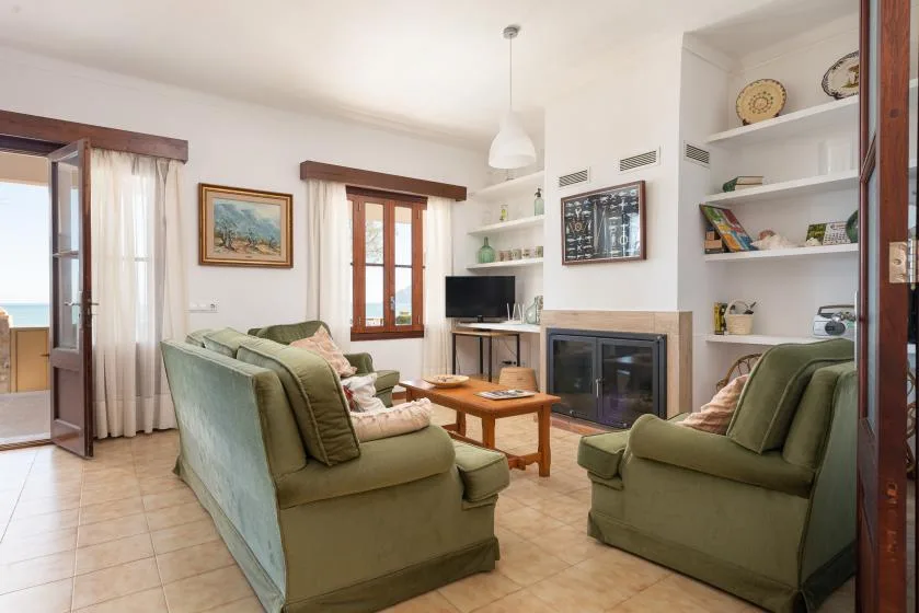 Living room with green seating, a coffee table, and a fireplace.