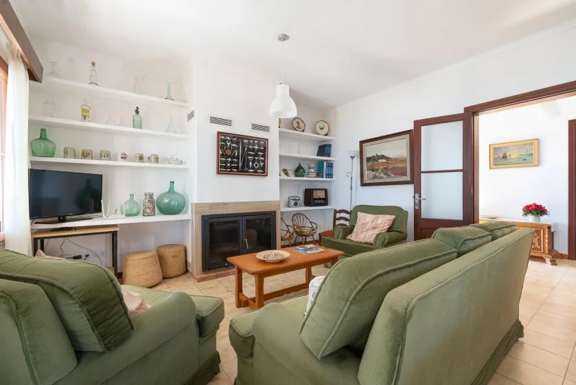 Living room with green seating, a coffee table, and built-in shelves.
