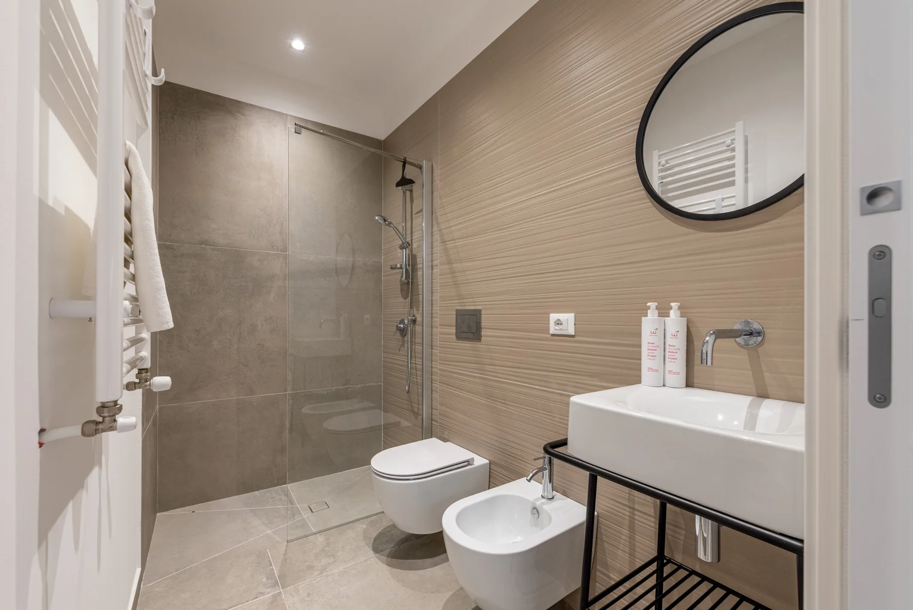 Un baño moderno con ducha, inodoro, bidé y lavabo.