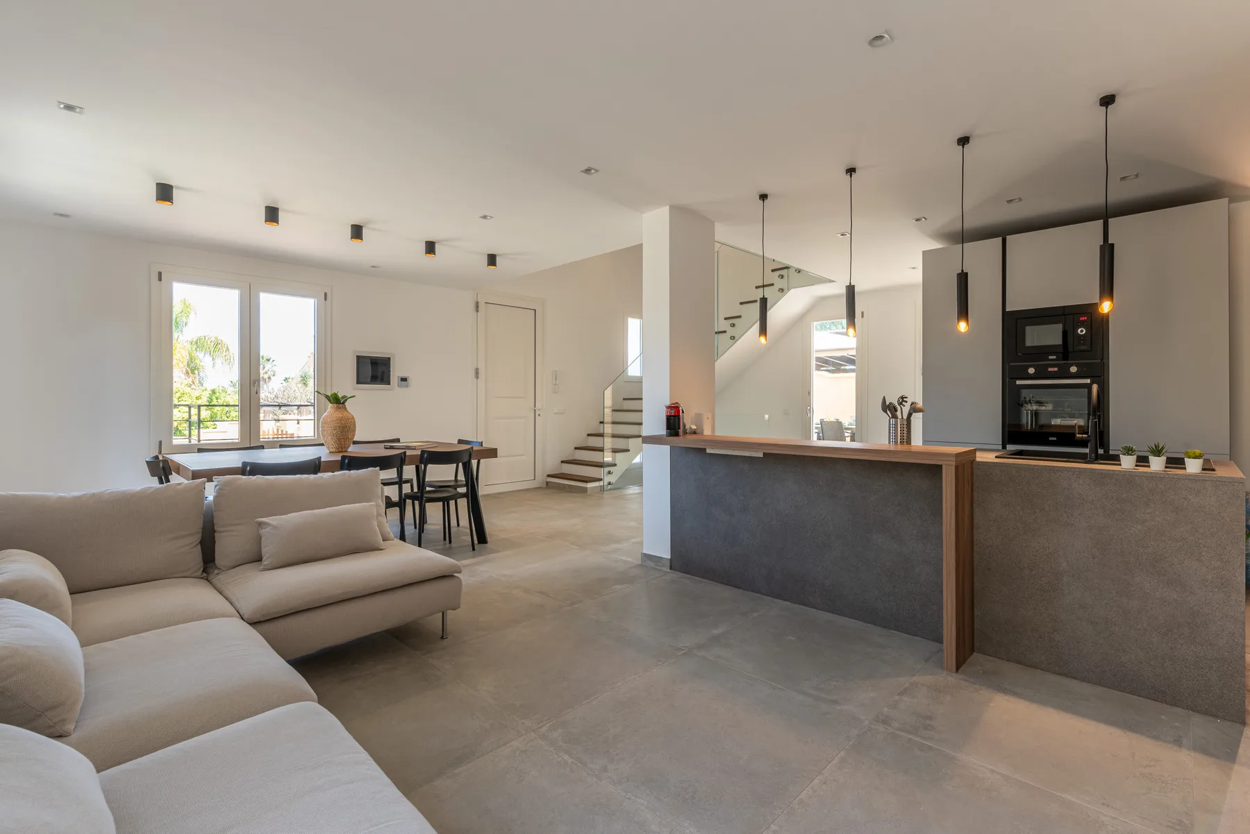 Sala y cocina de concepto abierto con una mesa de comedor y una barra.