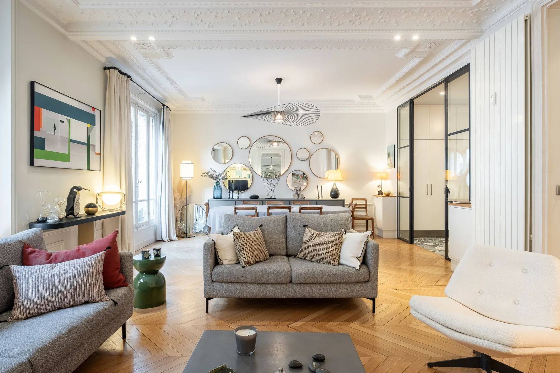 A bright living room with seating, a coffee table, and framed artwork.