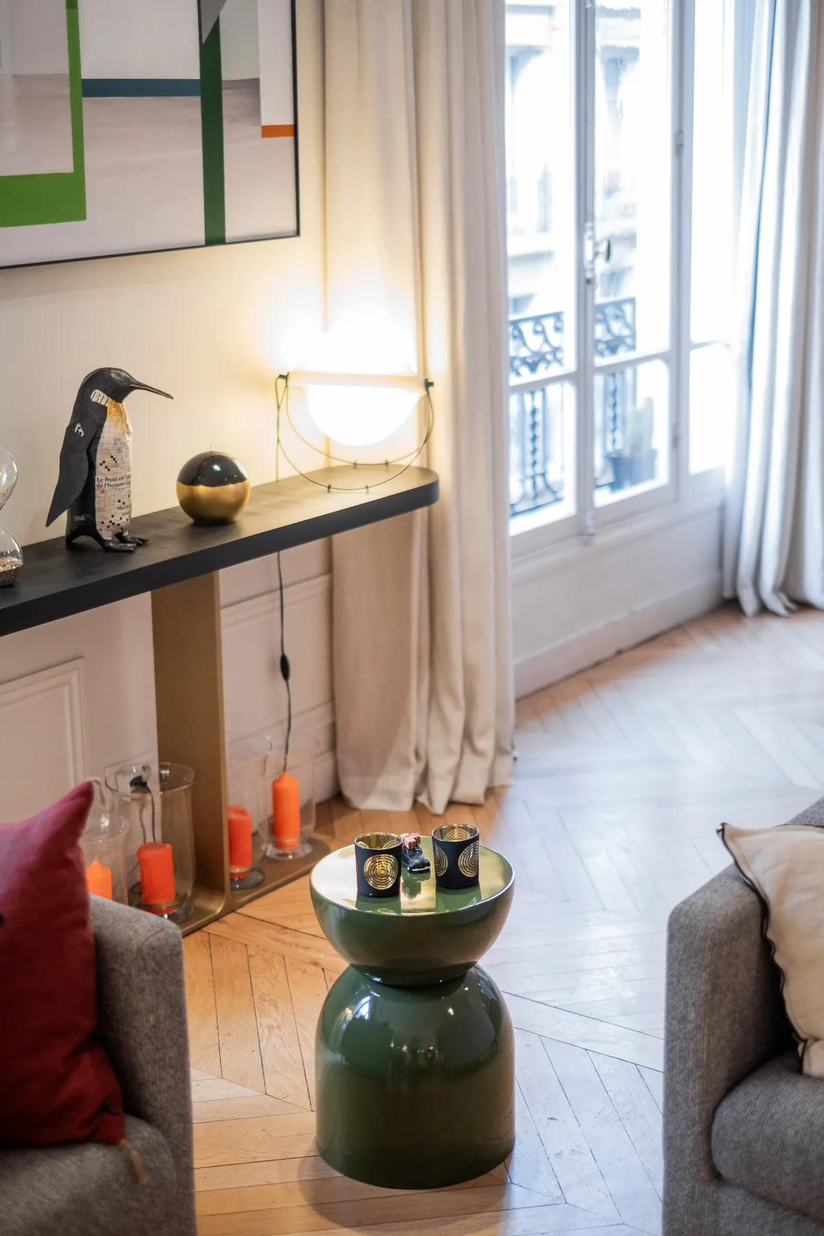 Una sala de estar con asientos, una mesa pequeña y ventanas altas.