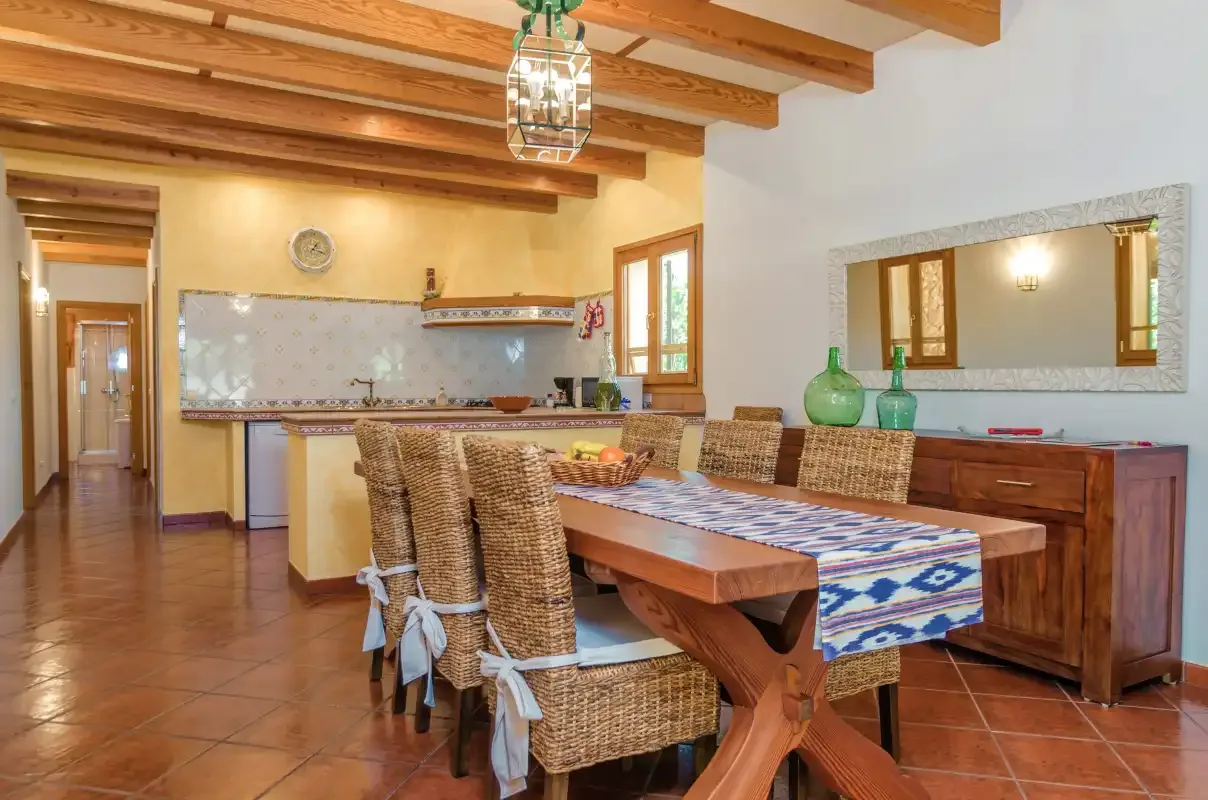 Comedor con una mesa larga de madera junto a una cocina abierta.
