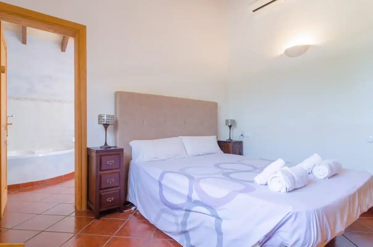 Un dormitorio con una cama doble y toallas colocadas sobre la cama.