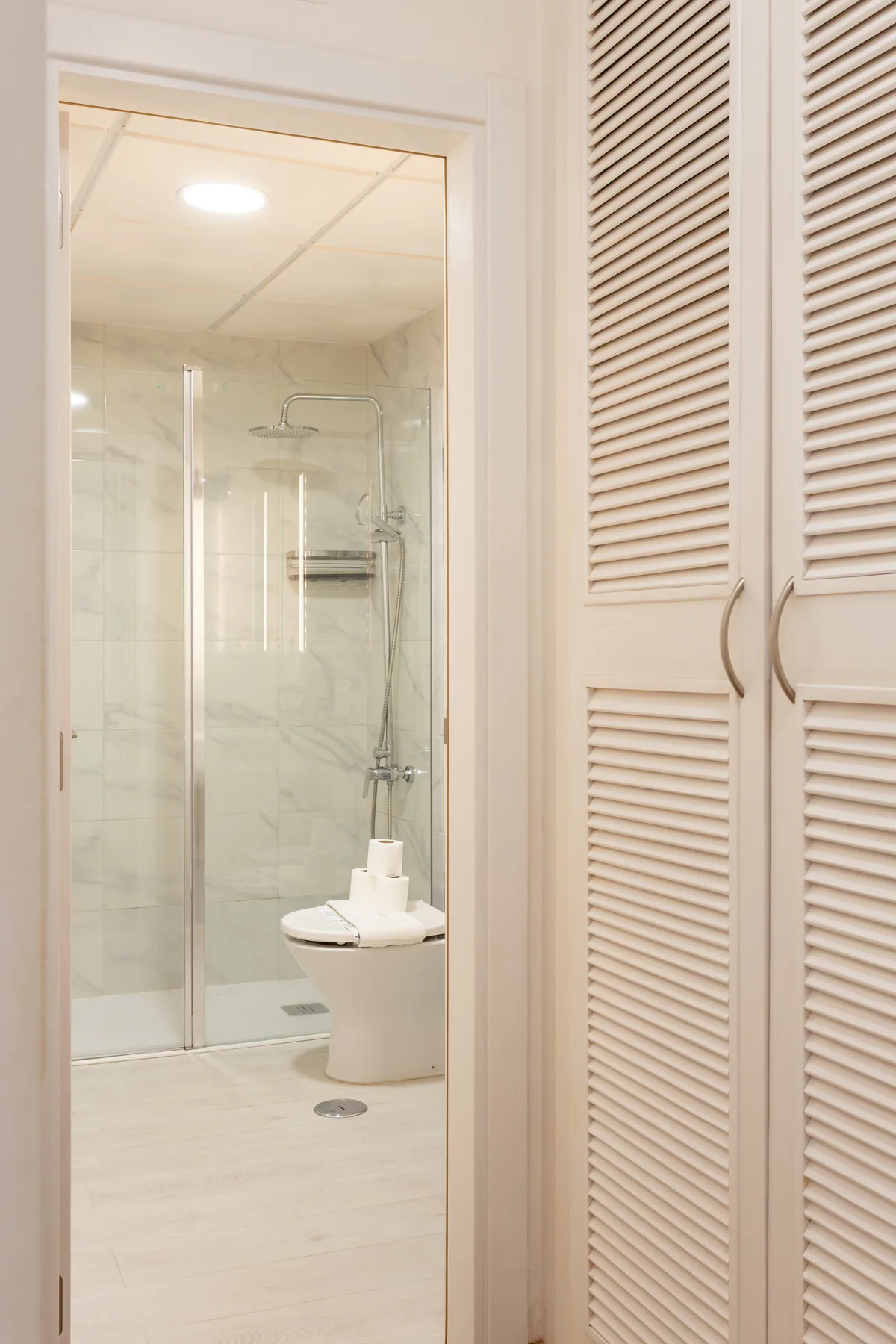A bathroom with a glass shower and a toilet.