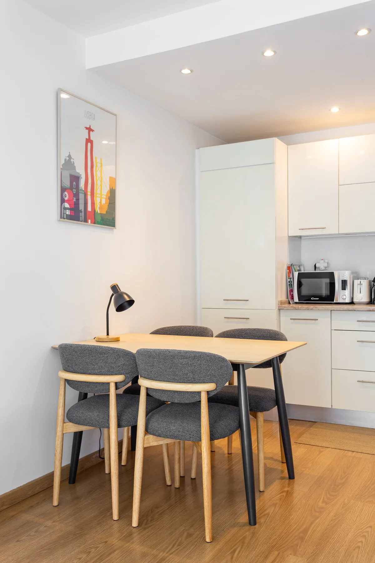 A dining area with a table and seating beside a compact kitchen.