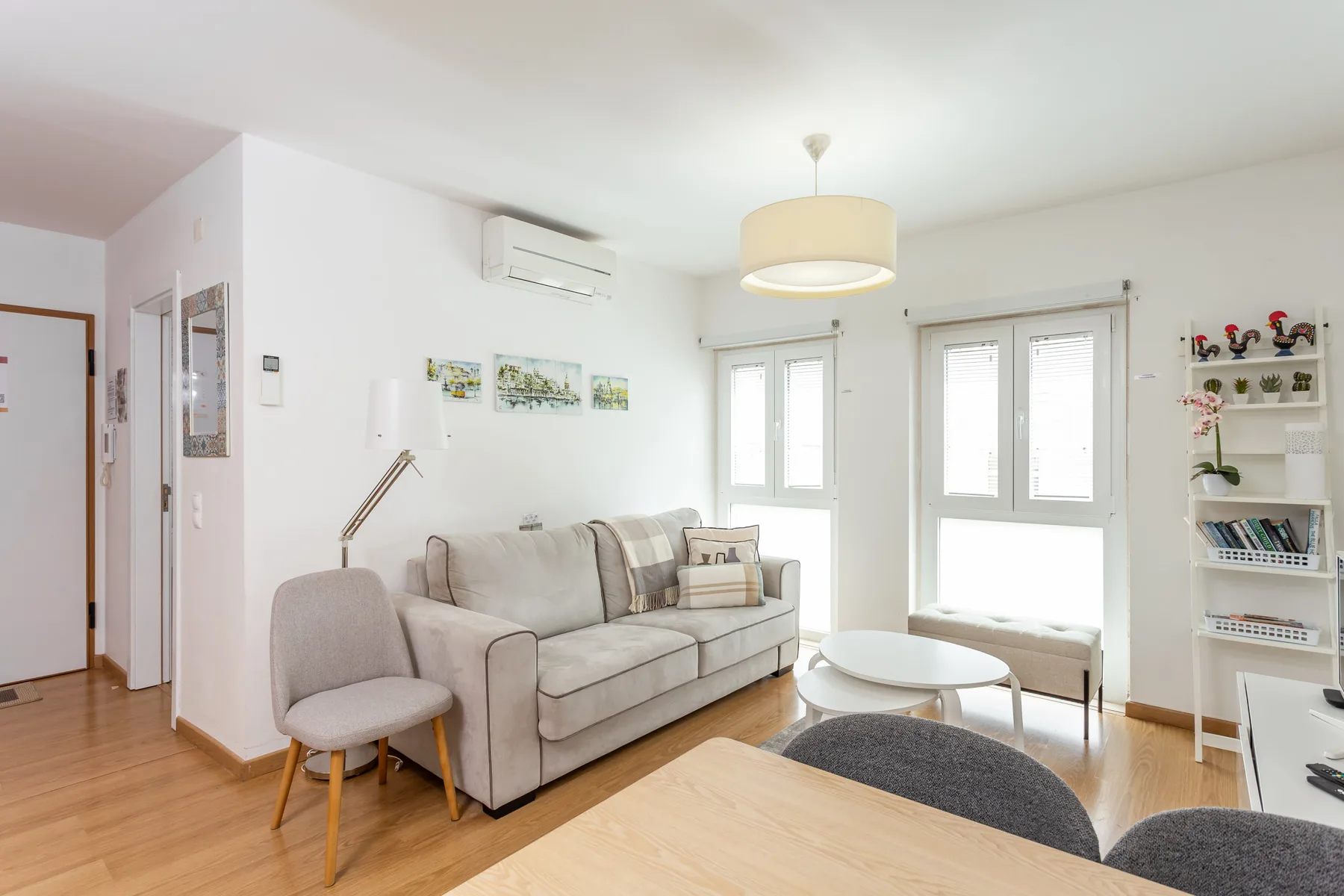 A bright living room with seating, a coffee table, and large windows.