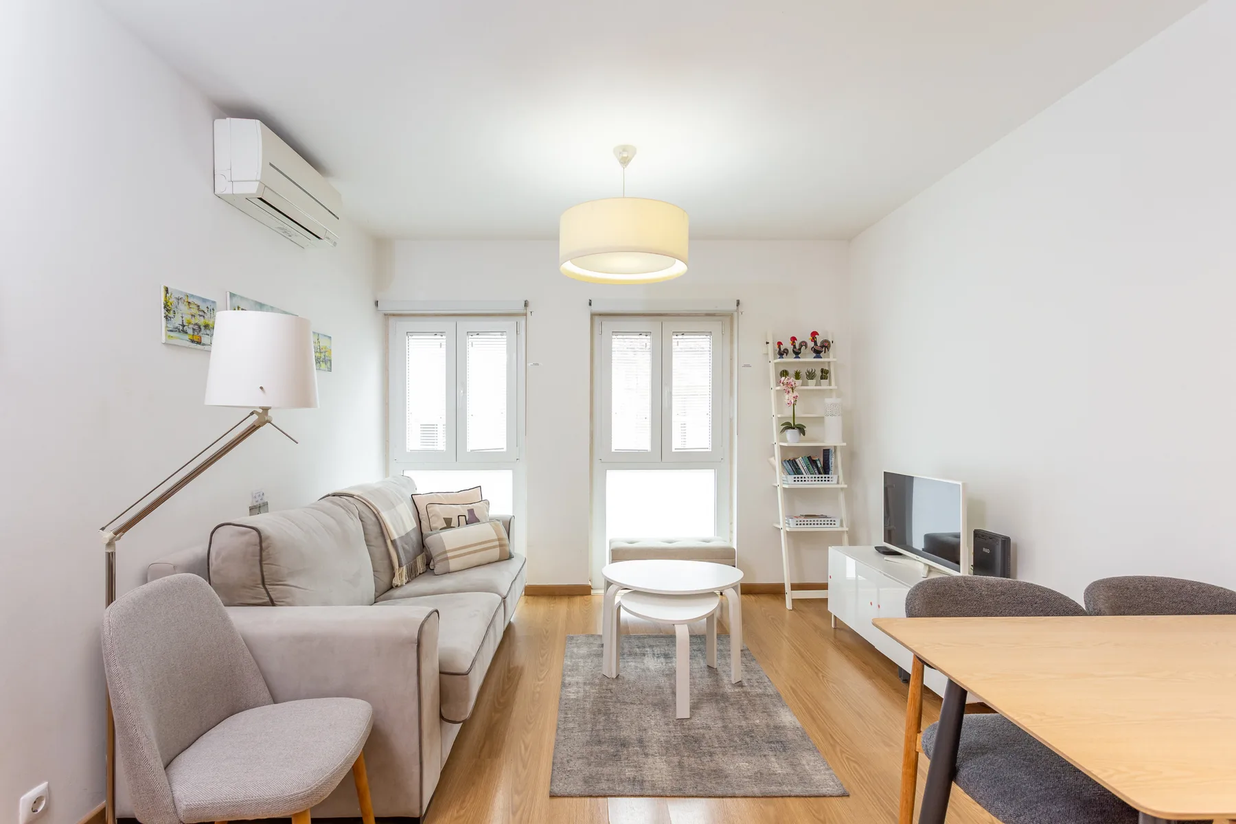 A bright living room with seating, a coffee table, and a television.