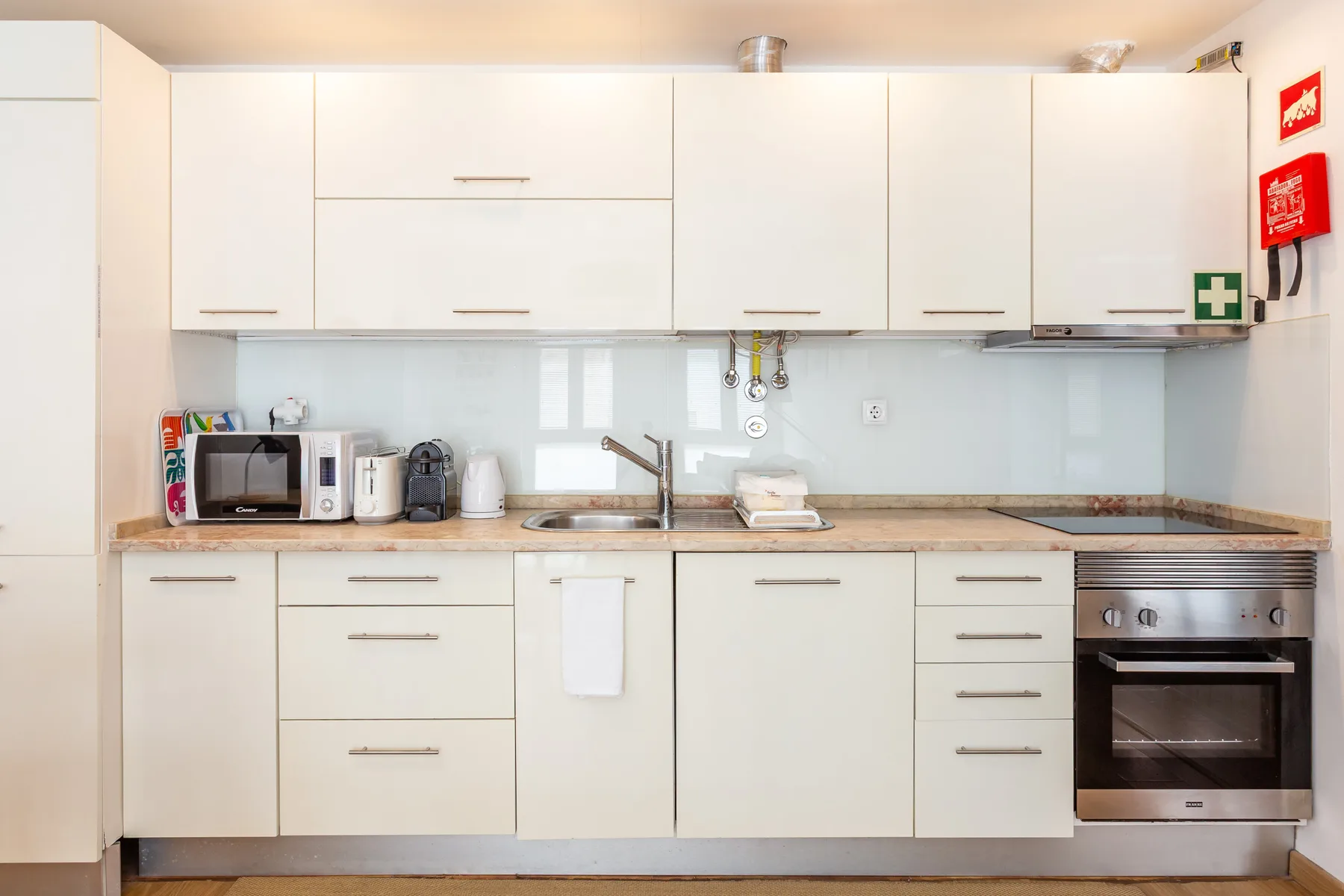 A bright kitchen with white cabinets, a countertop, and an oven.
