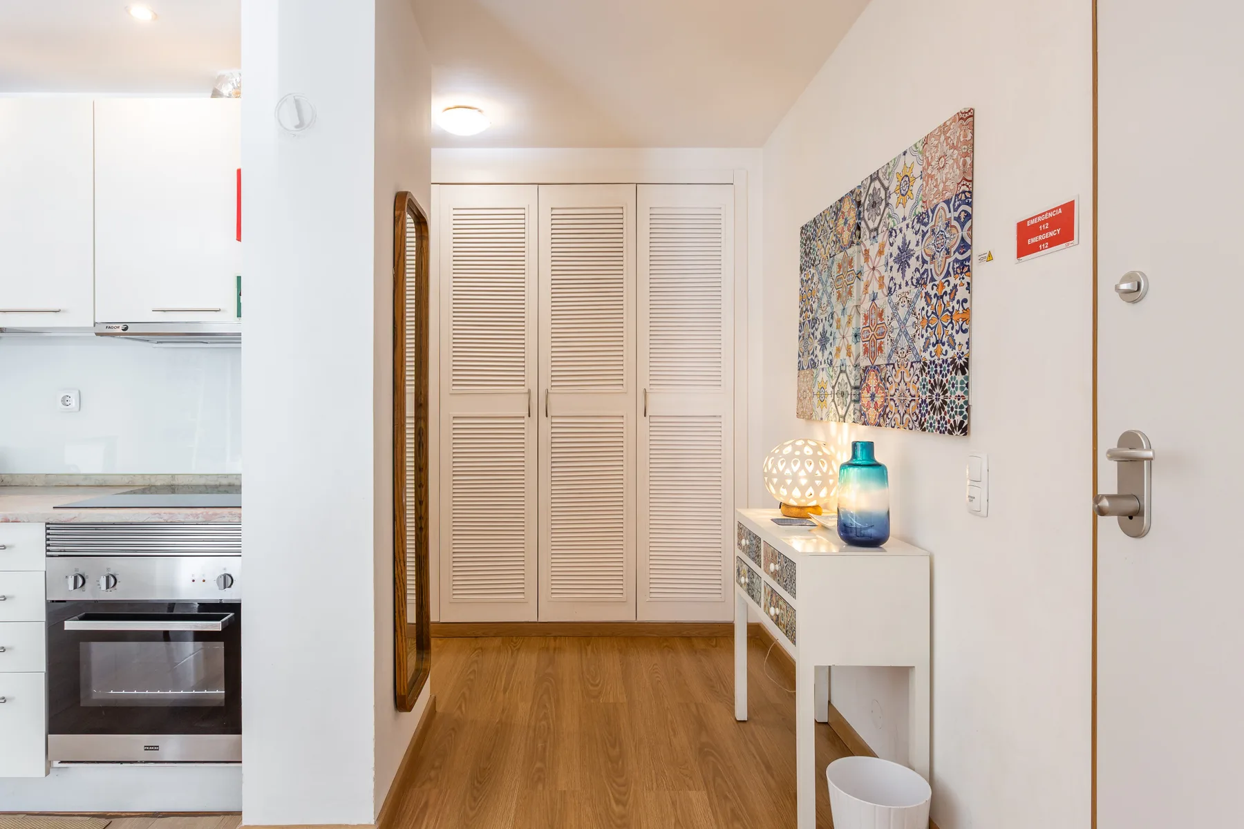 An apartment entryway with a console table and colorful wall art.