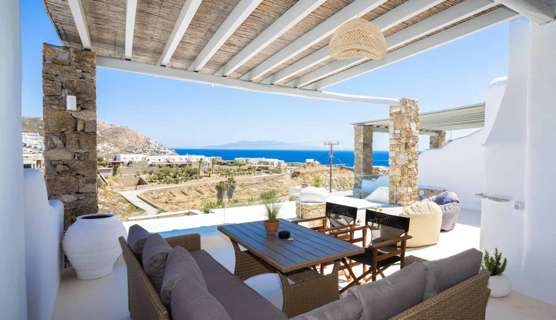 A covered outdoor dining and lounge area overlooks the sea.