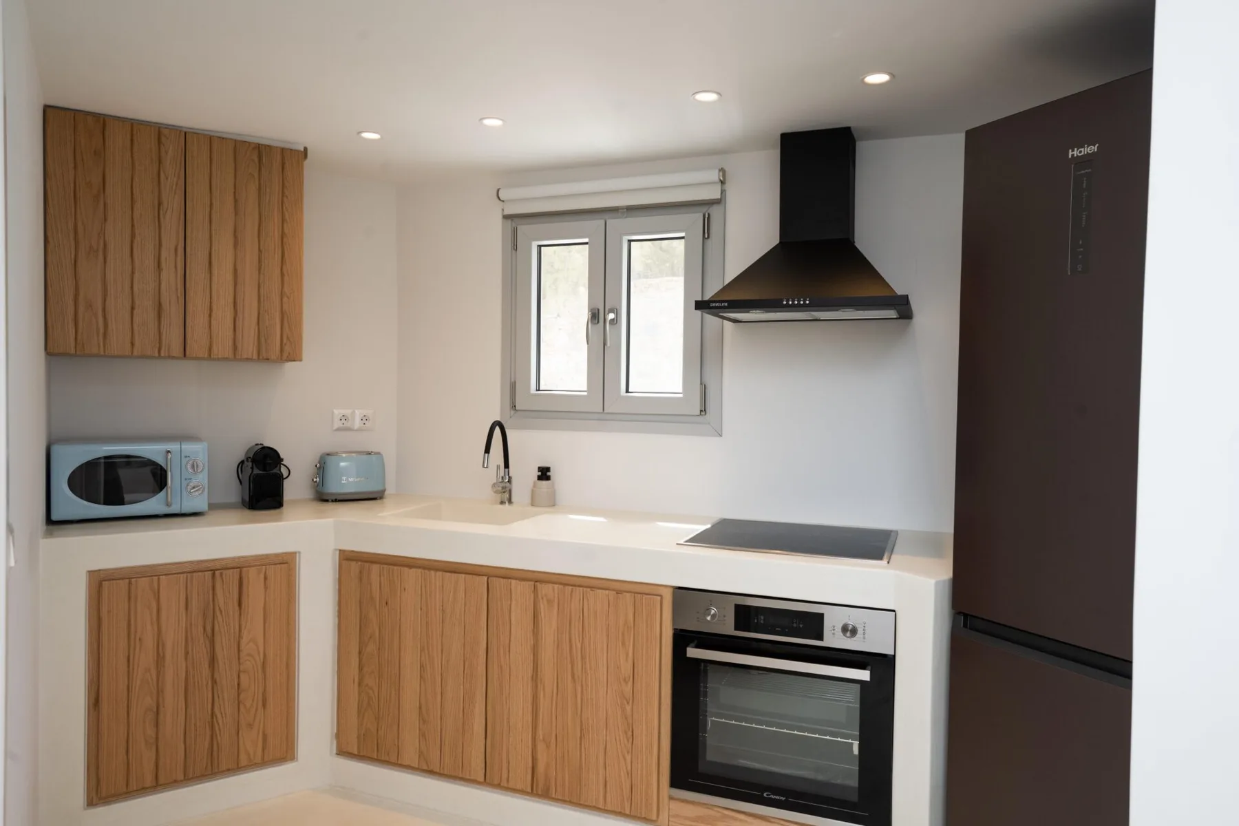 Una cocina moderna con gabinetes de madera, una placa de cocina y un horno.