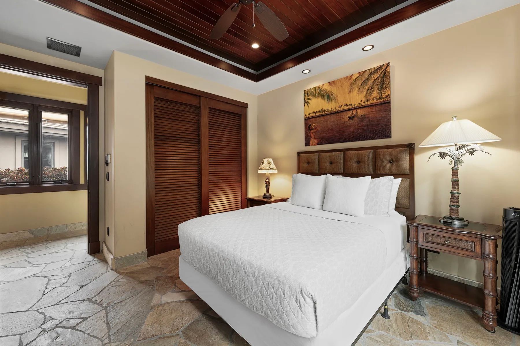 Un dormitorio con una cama bien hecha bajo un techo de madera oscura.