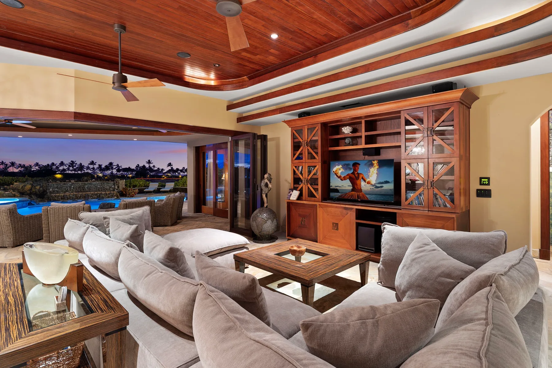 Una amplia sala de estar con asientos acolchados, una mesa de centro de madera y un gran mueble de entretenimiento.