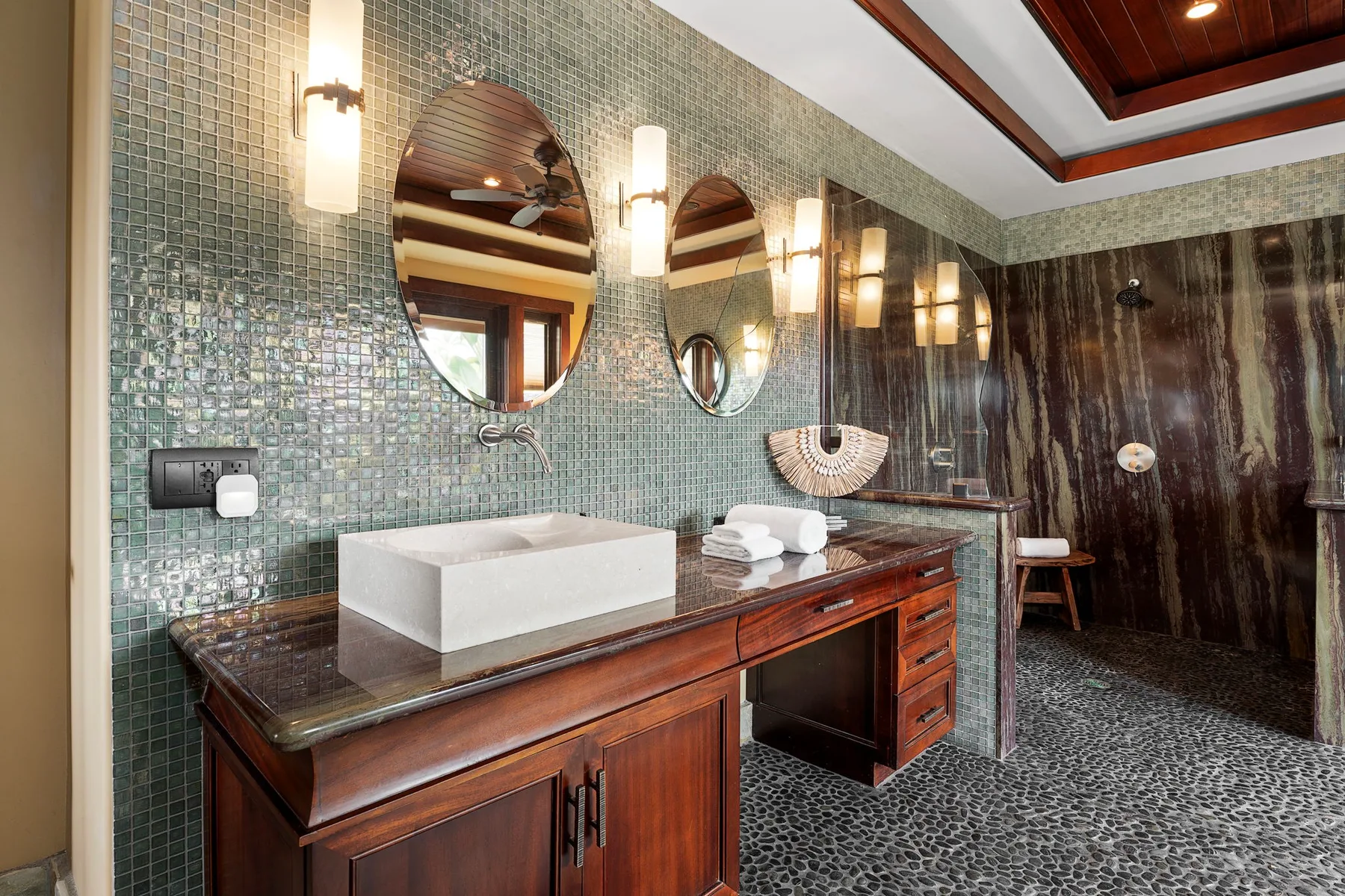 Un baño con azulejos, lavabo doble y zona de ducha.