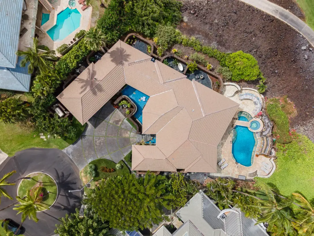 Vista aérea de una casa con piscina y vegetación alrededor.