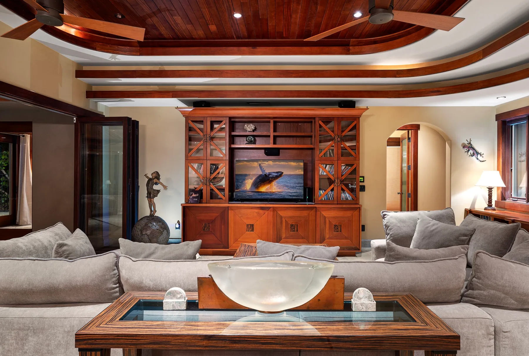 Una amplia sala de estar con asientos alrededor de un mueble de entretenimiento de madera.