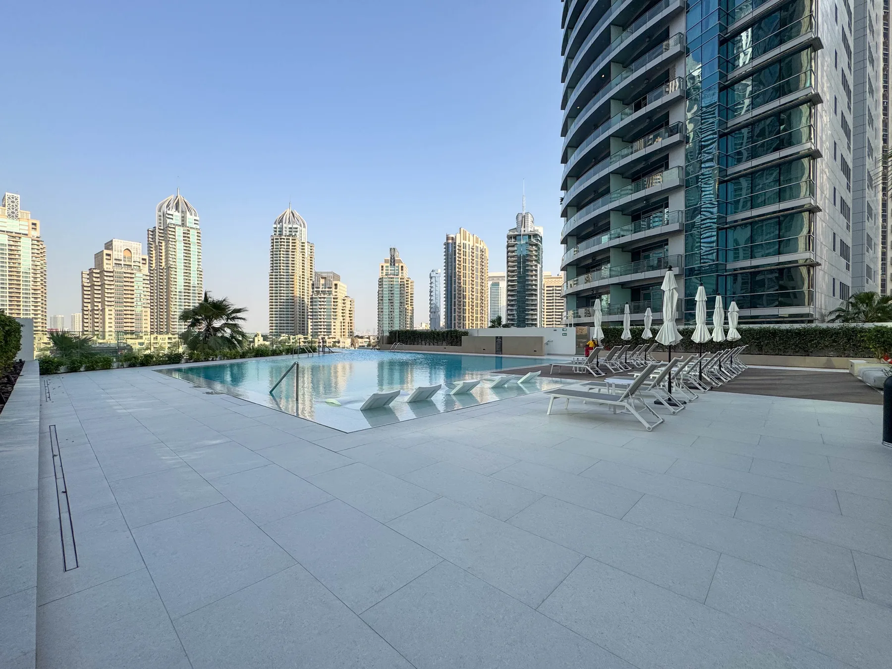 Una piscina en la azotea y asientos de descanso dan a un conjunto de edificios altos.