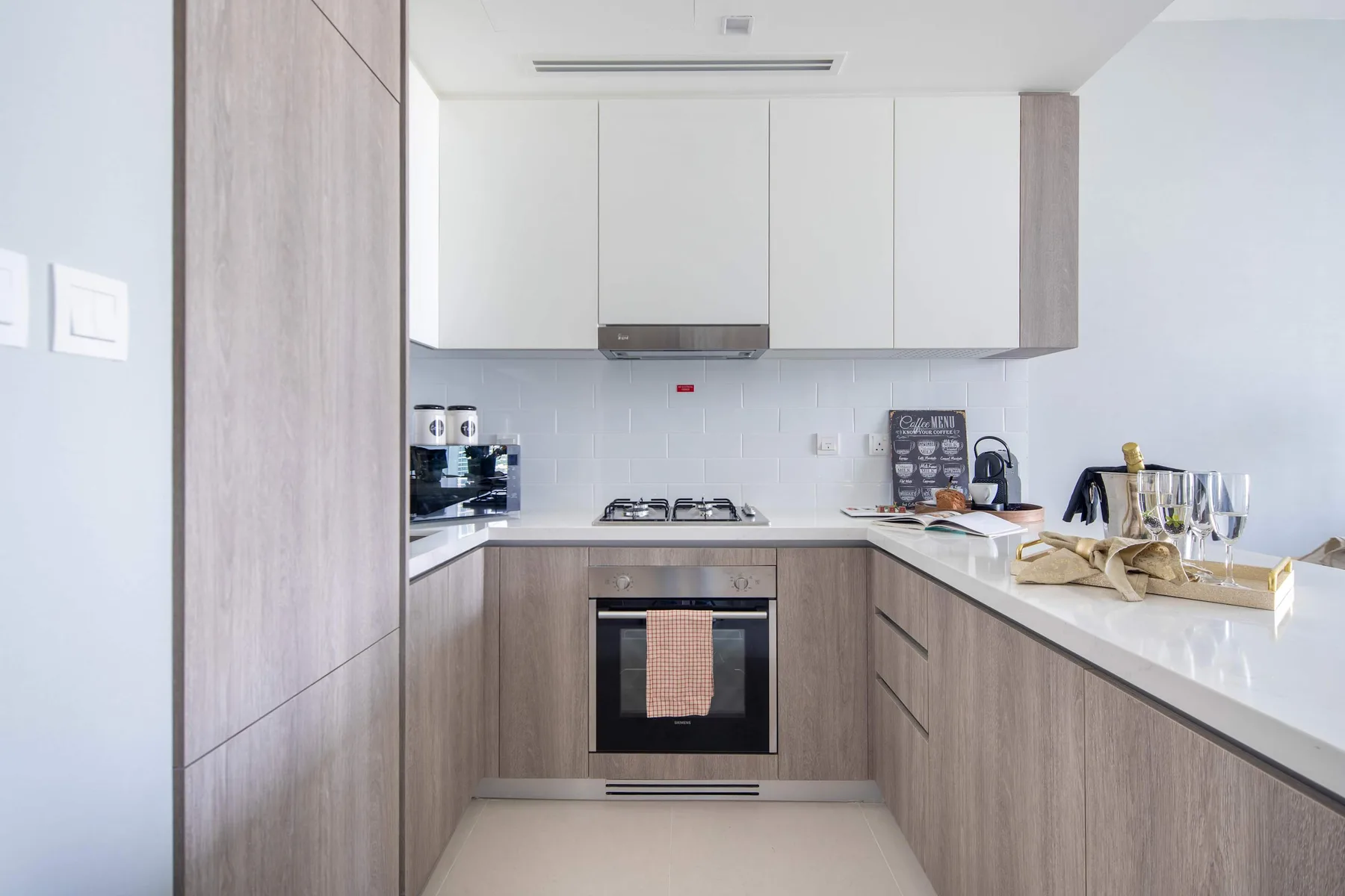 Una cocina moderna con armarios blancos y un horno empotrado.