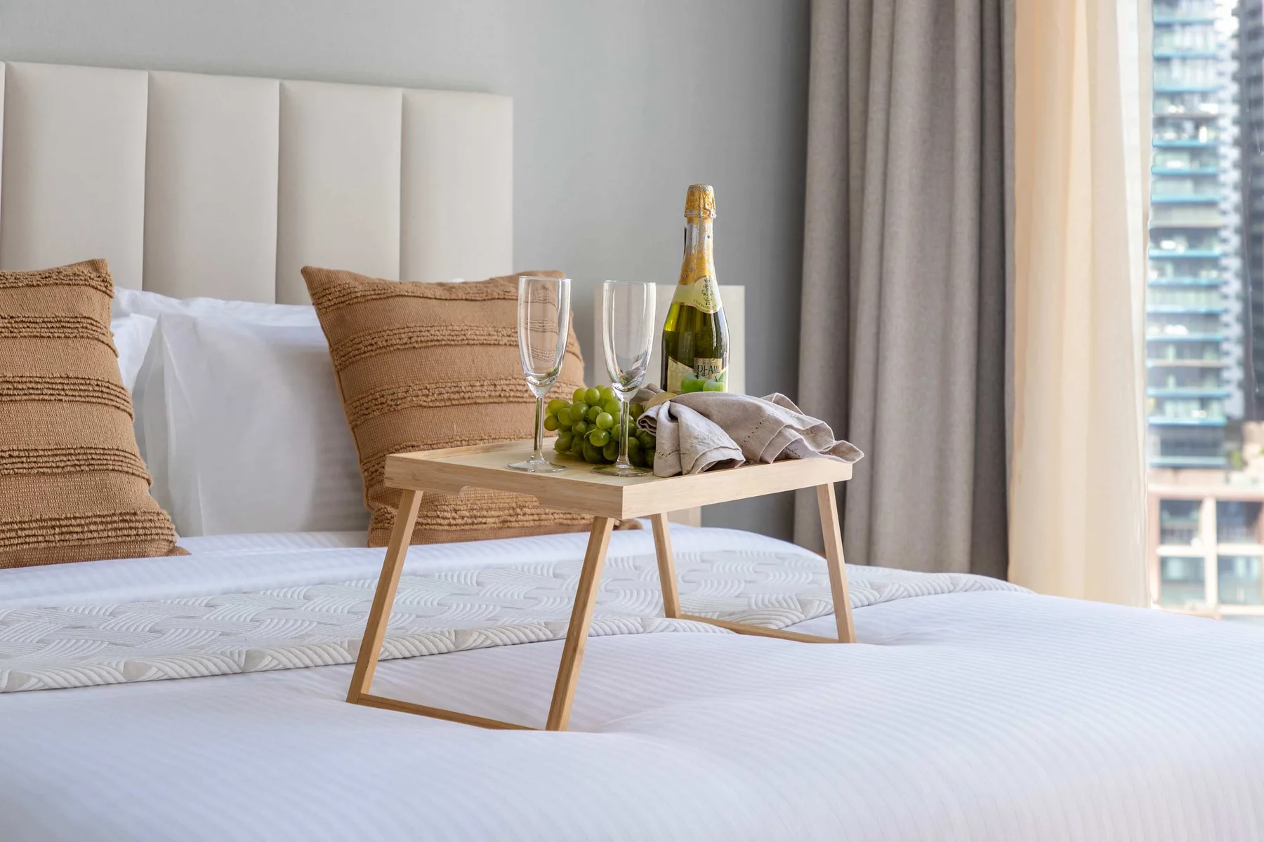 Un dormitorio con una bandeja de desayuno sobre la cama junto a la ventana.