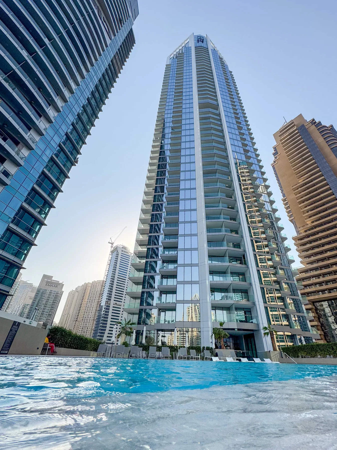 Una piscina está junto a varios edificios modernos de gran altura.