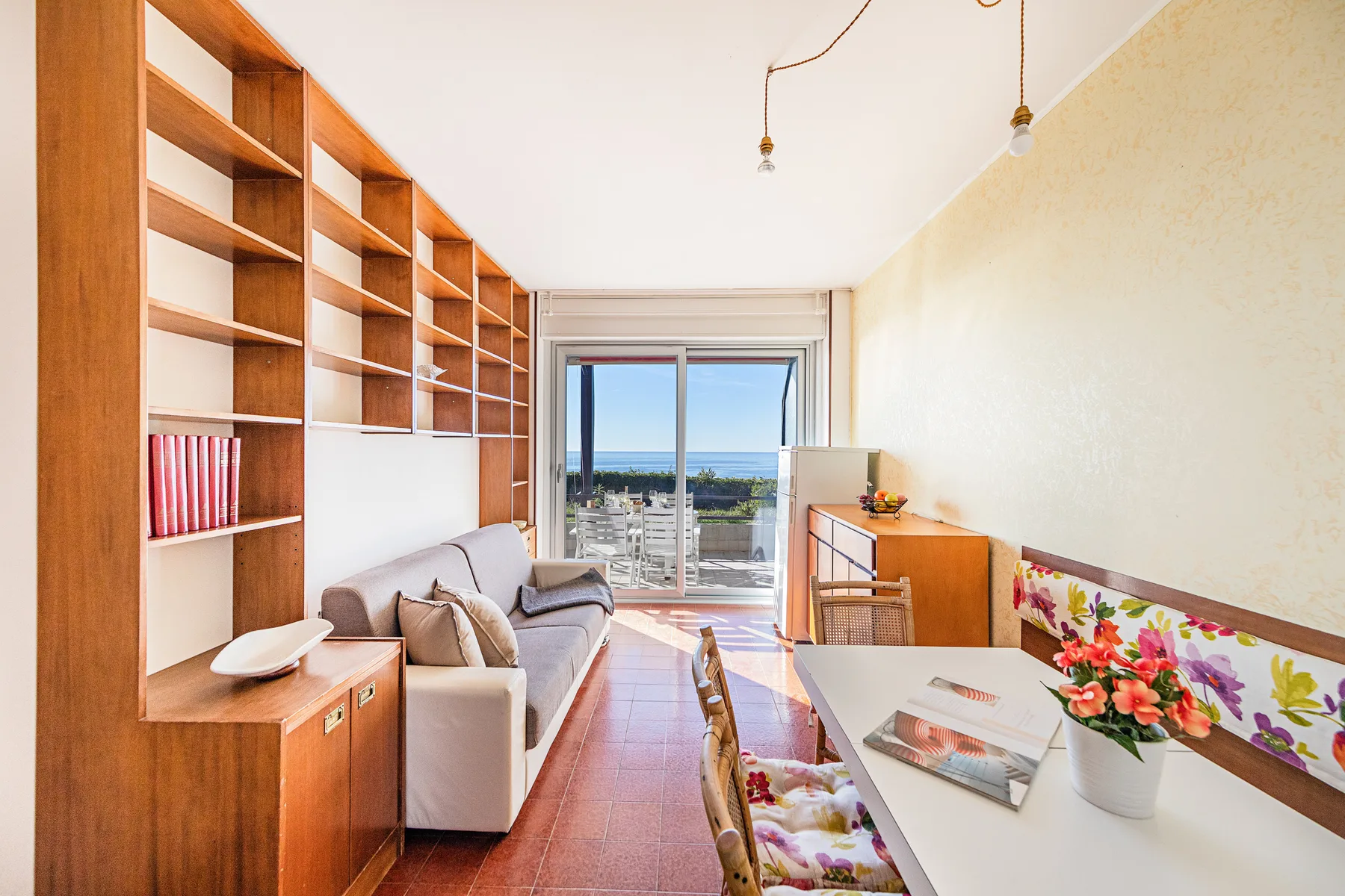 Una luminosa sala de estar y comedor se abre a un balcón con vistas al mar.