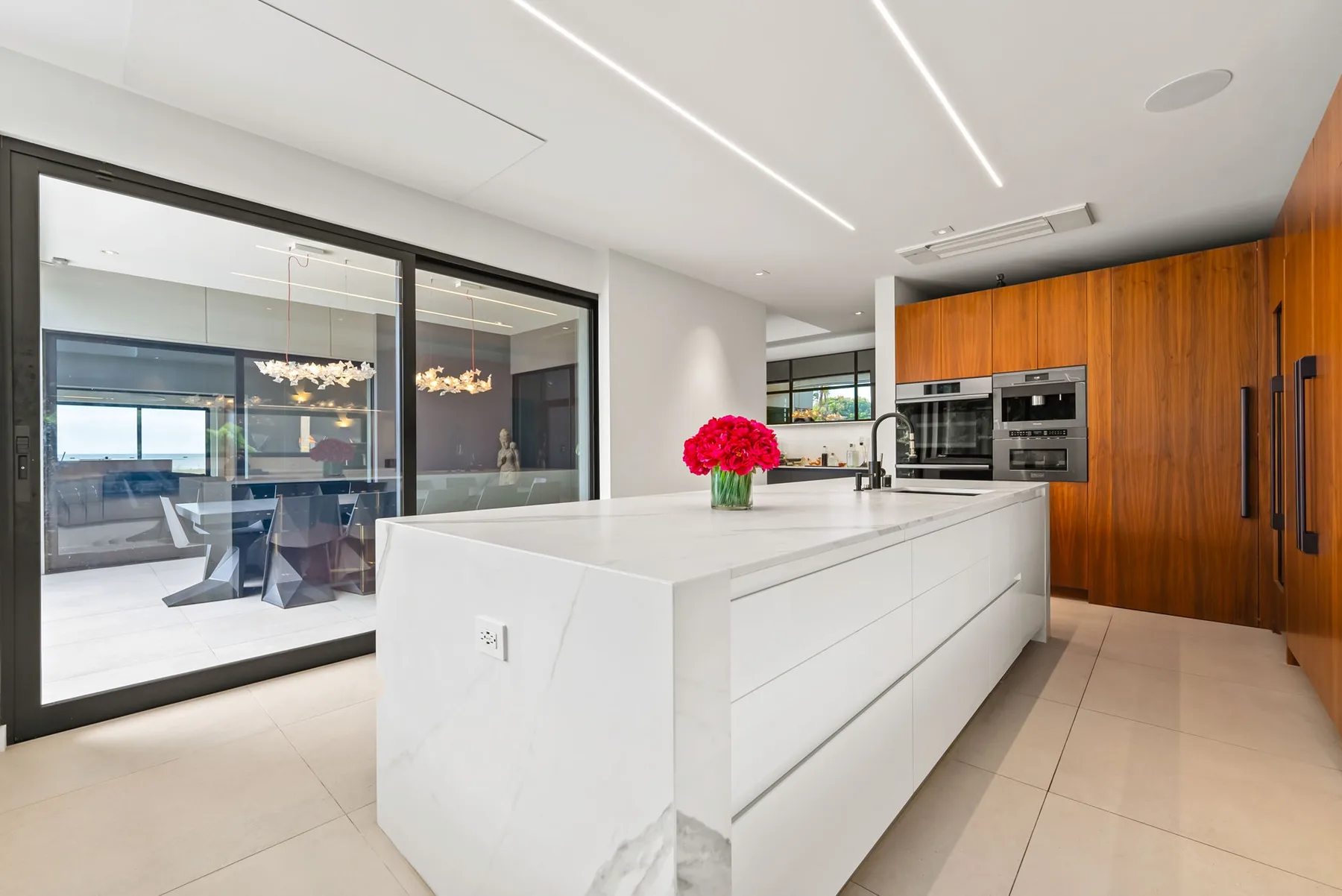 Una cocina moderna con una gran isla blanca y gabinetes de madera.