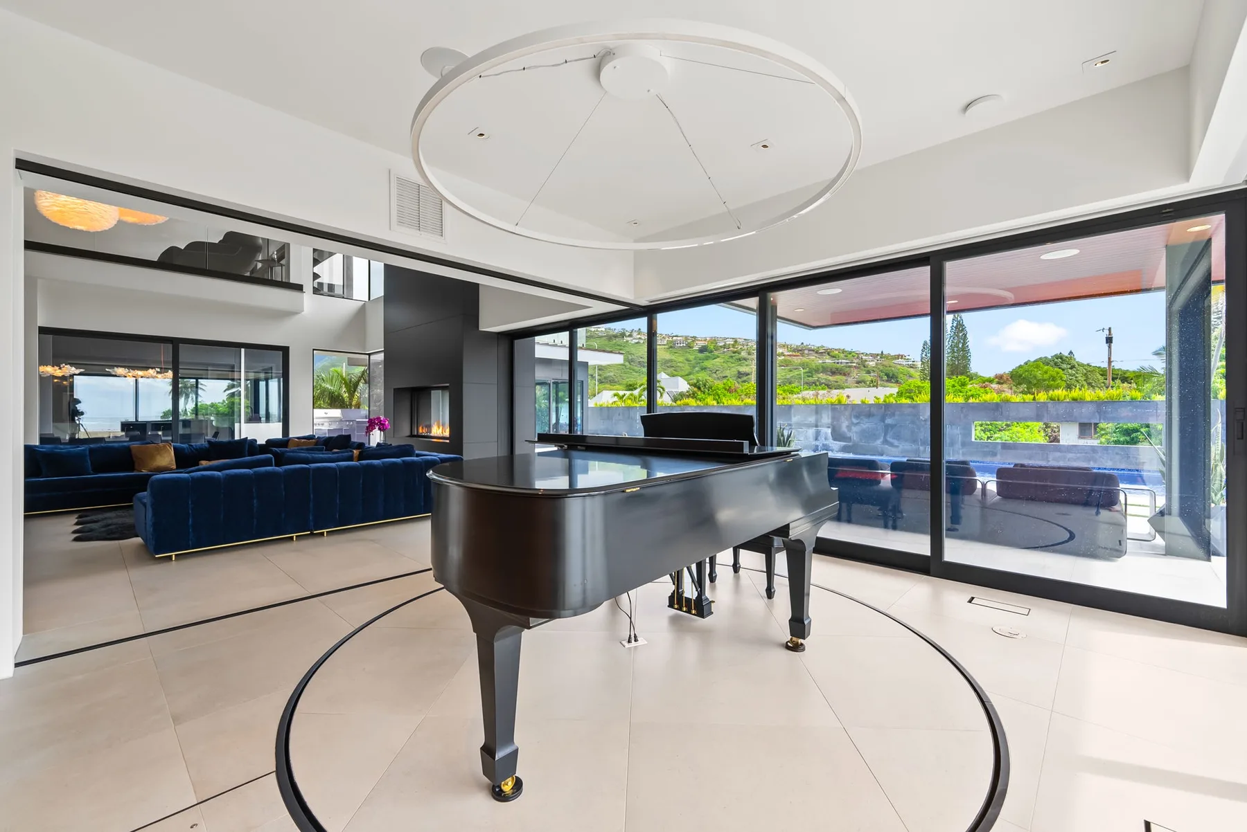 Un piano de cola está en una sala luminosa con ventanales de piso a techo.
