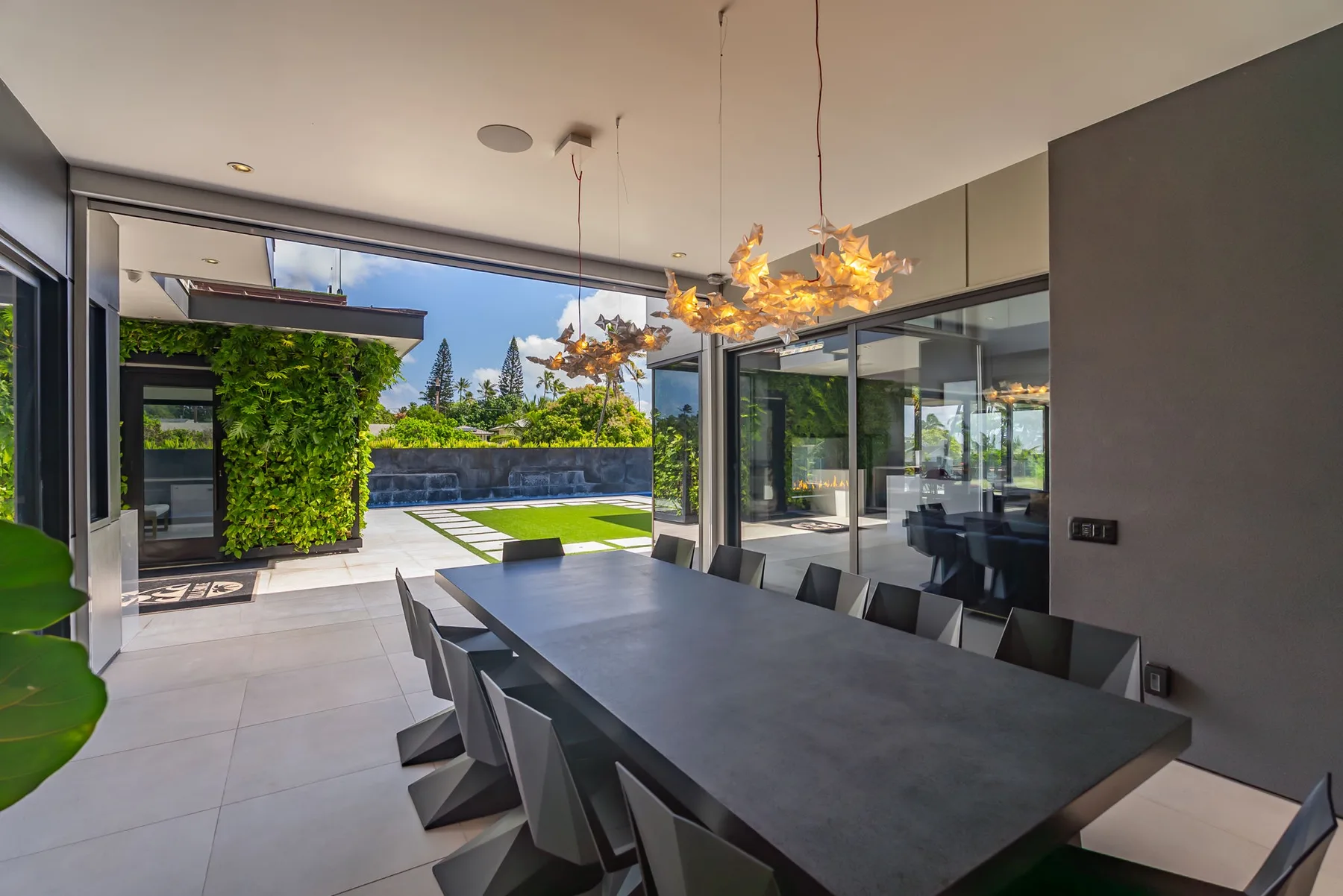 Un comedor moderno se abre a un patio y un jardín.