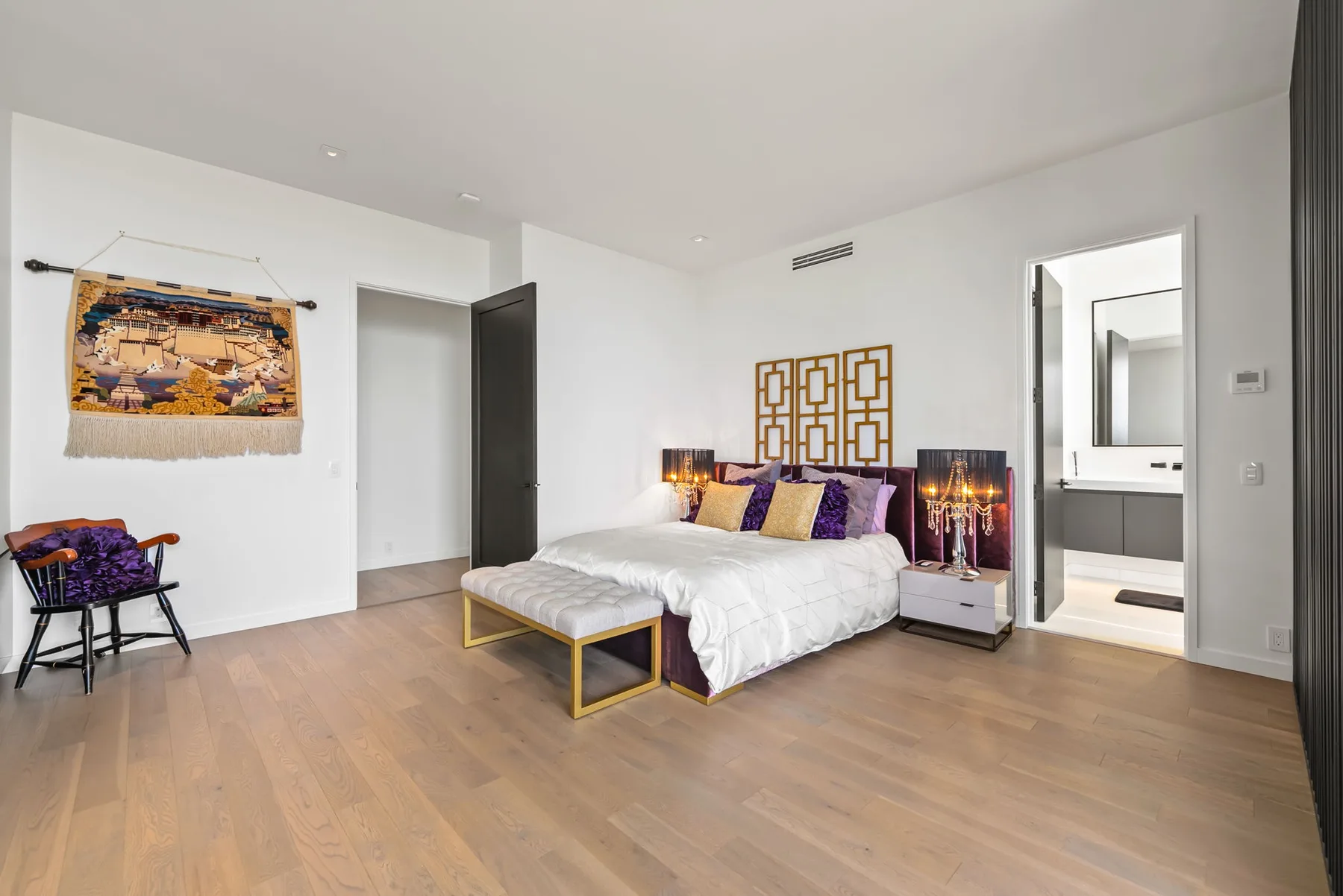 Un dormitorio luminoso cuenta con una cama, mesitas de noche y suelo de madera clara.