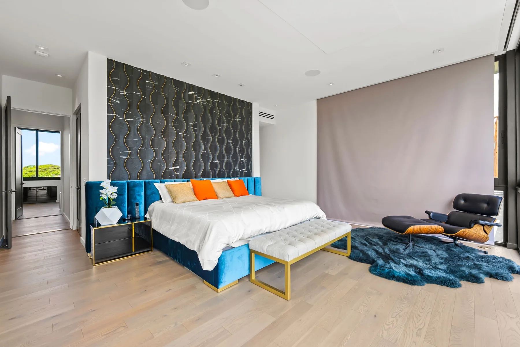 Un dormitorio moderno con una cama grande y un cabecero tapizado azul.