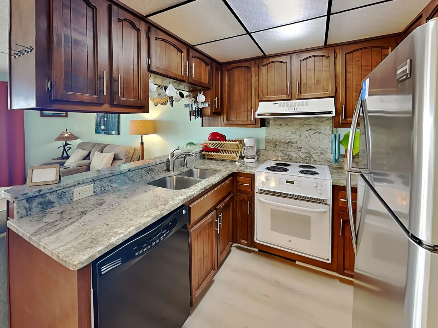 A compact kitchen with wooden cabinets, a stove, and a refrigerator.