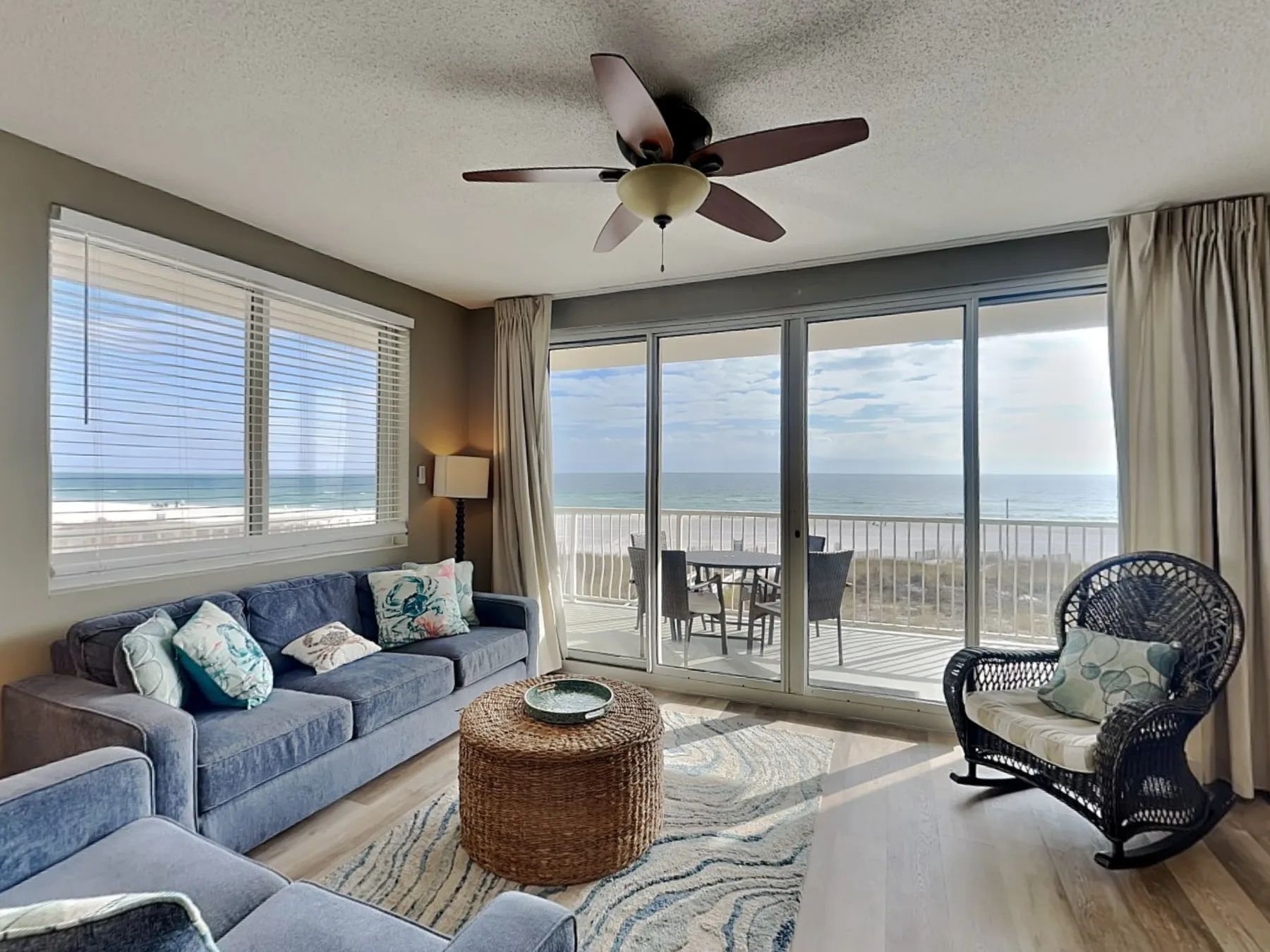 A living room with seating beside large windows overlooking the ocean.