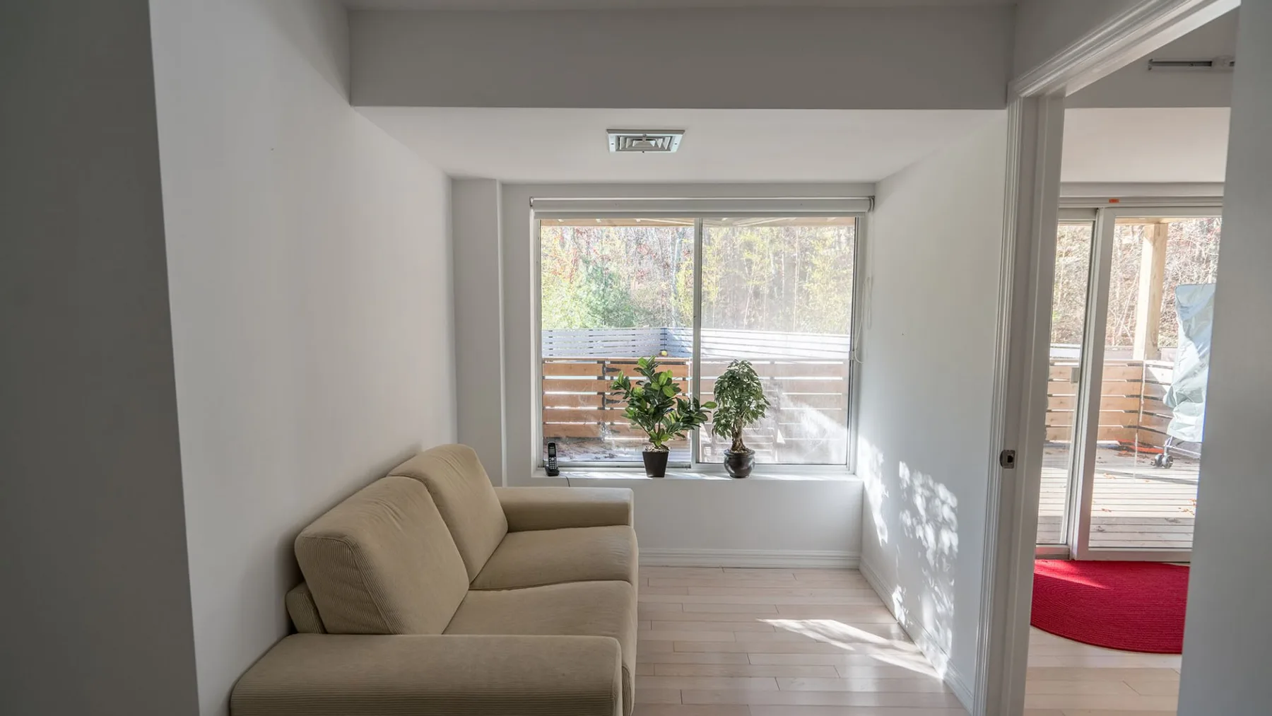 A bright living area with a beige sectional and a large window.