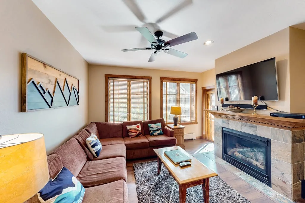 Living room with sectional seating, a coffee table, and a fireplace.