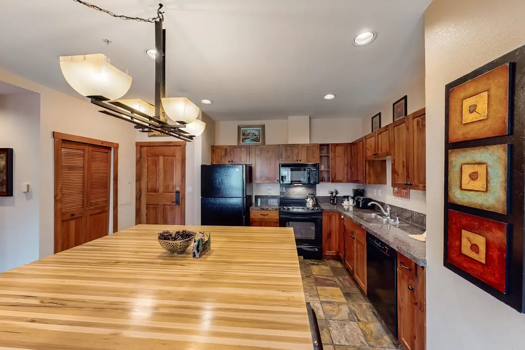 A kitchen with wooden cabinets, stainless-steel appliances, and a large central island.